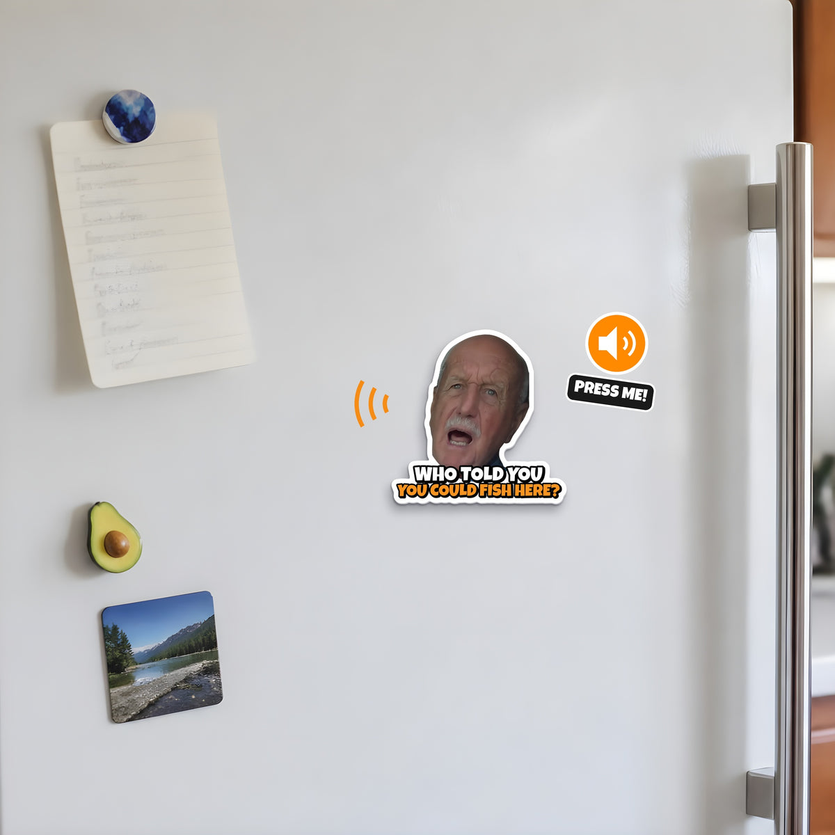 Close-up of the Who Told You You Could Fish Here? sound fridge magnet on the fridge door next to the handle, Press Me sound badge